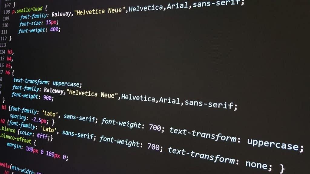 Coding screen showing HTML and CSS code snippets on a dark background, representing web development and web design services for the Durham Region.