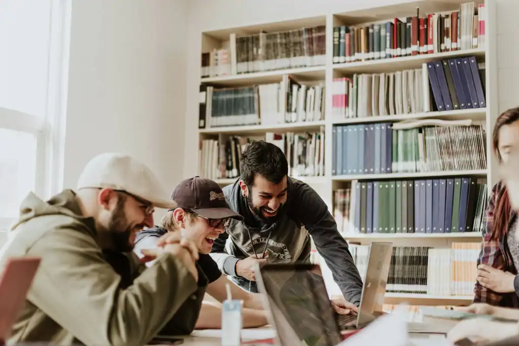 Pixabay_photo_of_group_of_people_having_fun_and_laughing_around_laptop_in_study_room_with_bookshelves.jpg.