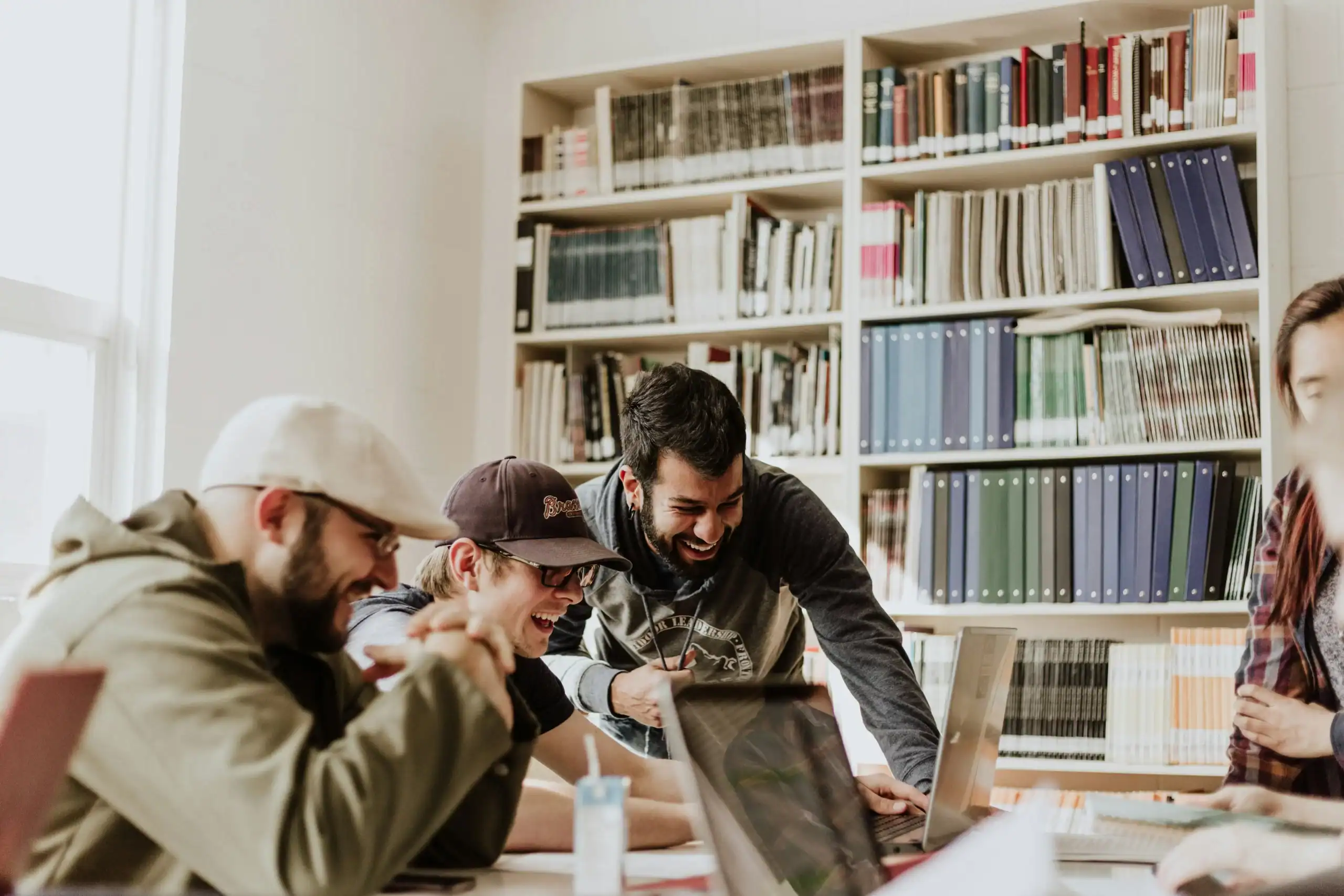 Pixabay_photo_of_group_of_people_having_fun_and_laughing_around_laptop_in_study_room_with_bookshelves.jpg.